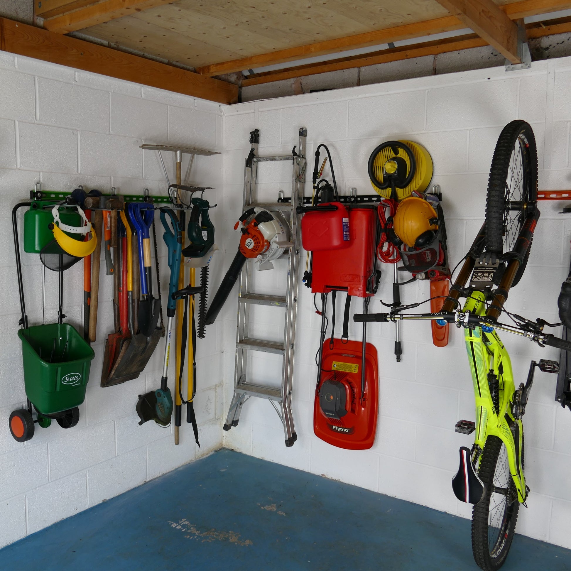 Garage Wall Storage Rack. Inside of a garage with wall mounted storage racks showing how bikes, sports equipment and garden tools can be stored on wall mounted racks