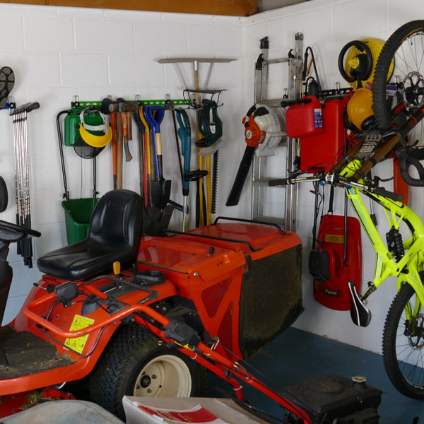 garden tool storage - Inside of a garage with wall mounted storage racks showing how bikes, sports equipment and garden tools can be stored on wall mounted racks